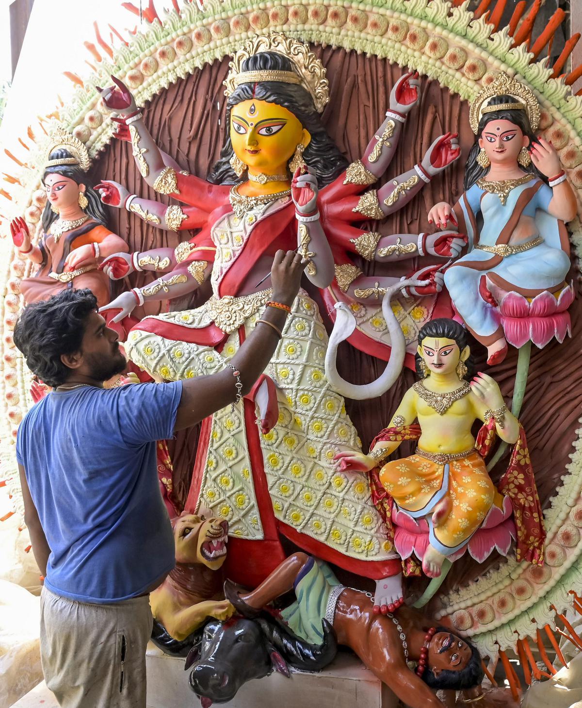  An artisan gives final touches to an idol of Goddess Durga ahead of Durga Puja festival, in Nadia, on Oct. 14, 2023.  